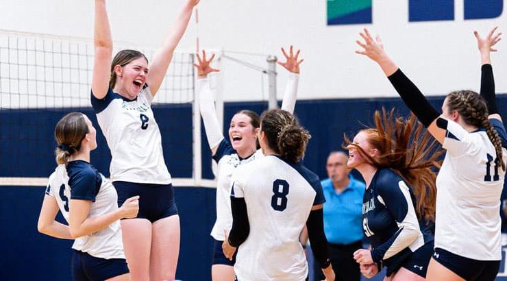 Women's volleyball team celebrates win.